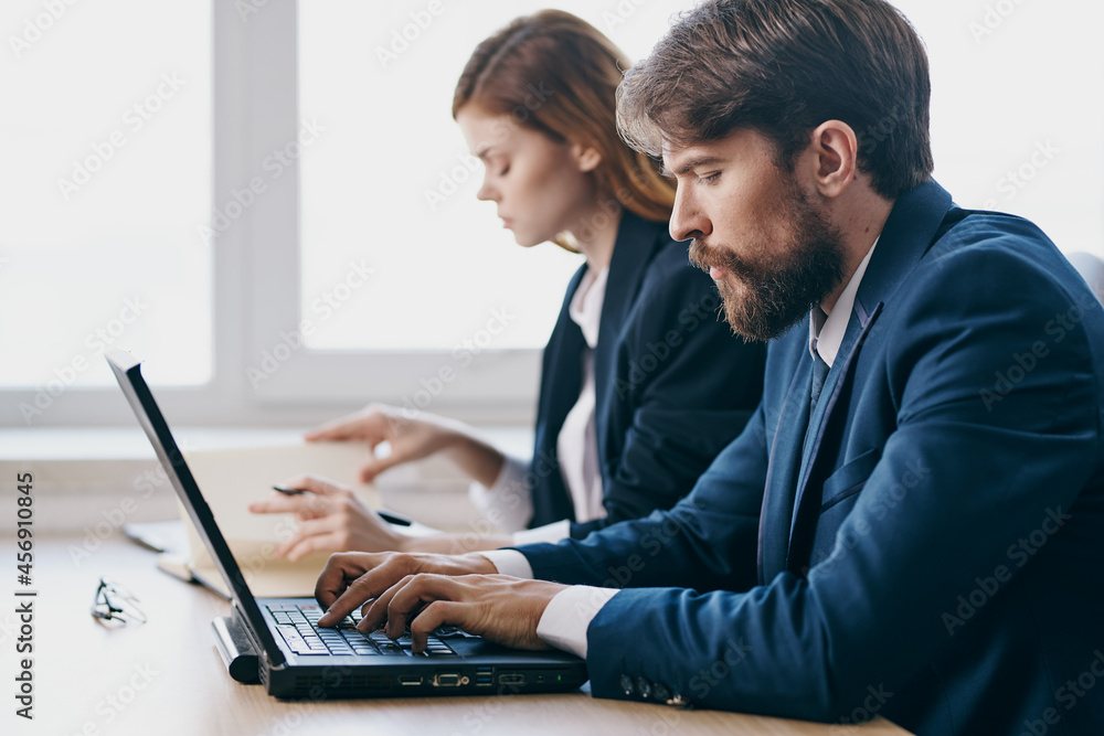 colleagues sitting at a desk with a laptop communication finance technologies colleagues sitting at a desk with a laptop communication finance technologies
