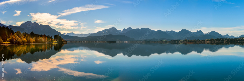 panoramic landscape in Bavaria at lake Forggensee mirroring alps mountains