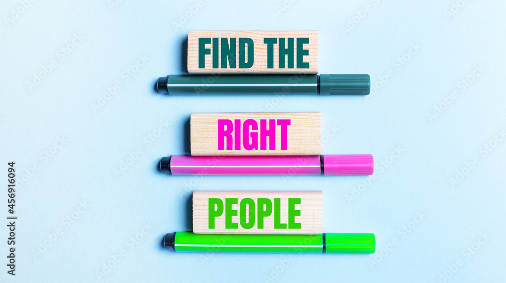 On a light blue background, there are three multi-colored felt-tip pens and wooden blocks with the FIND THE RIGHT PEOPLE