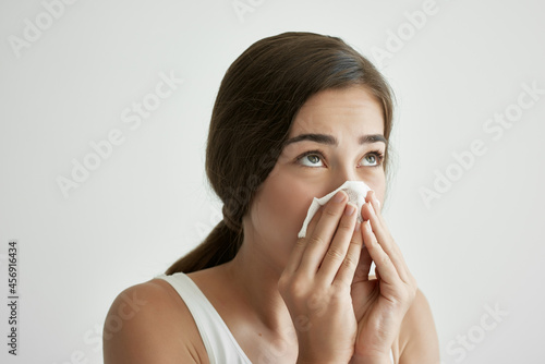 woman wiping her nose with a handkerchief cold health problems disorder