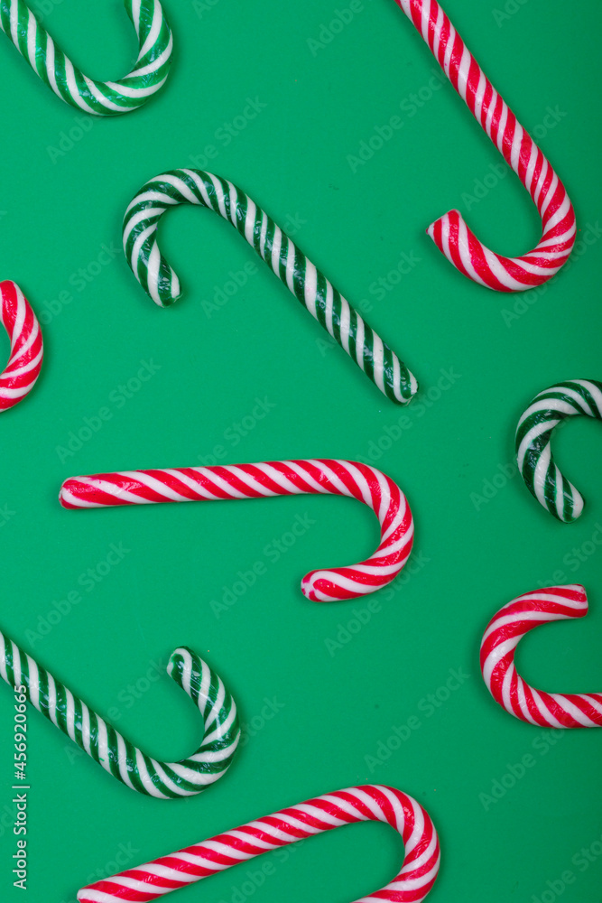 Fototapeta premium Composition of multiple green and red candy canes on green background