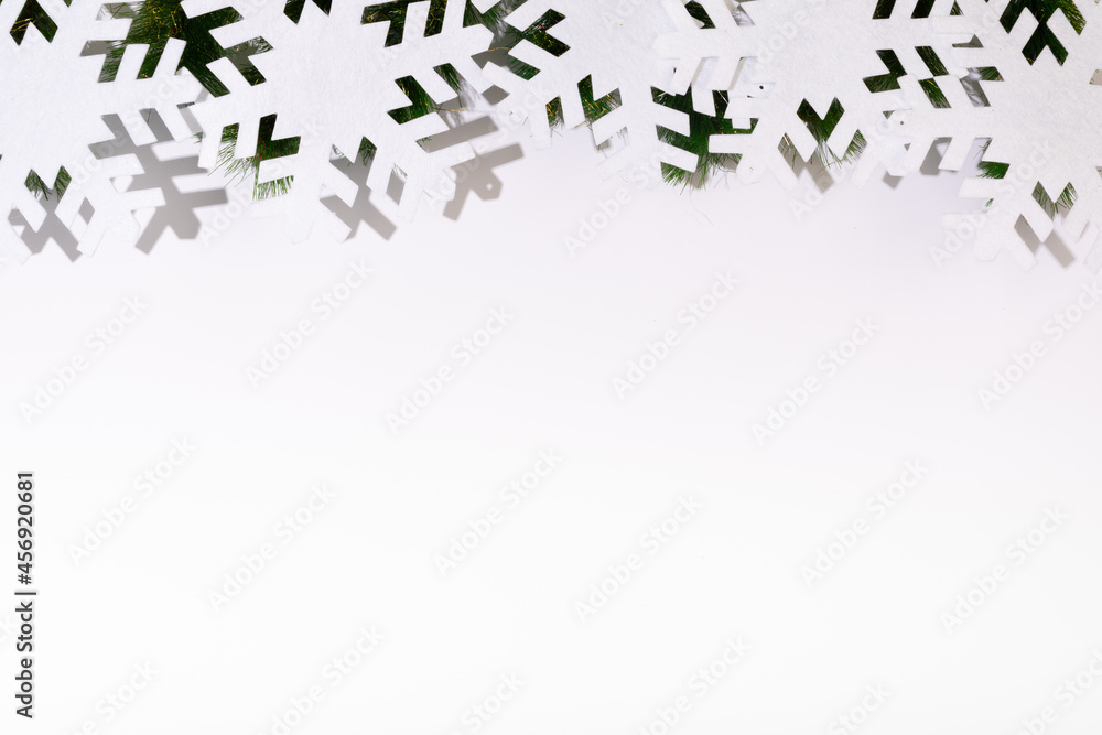 Composition of fir tree branches with snowflakes and copy space on white background Composition of fir tree branches with snowflakes and copy space on white background