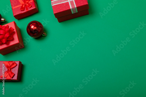 Composition of baubles with presents and copy space on green background