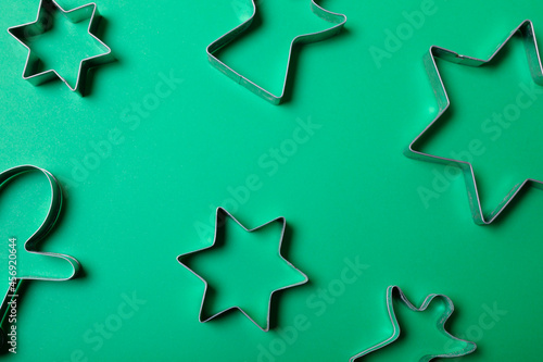 Composition of stars and angels ginger man cookie cutters on green background