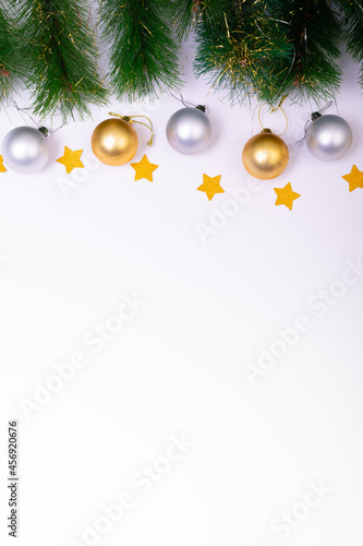 Composition of fir tree branches with baubles, stars and copy space on white background