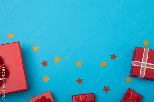 Composition of presents with stars and copy space on blue background