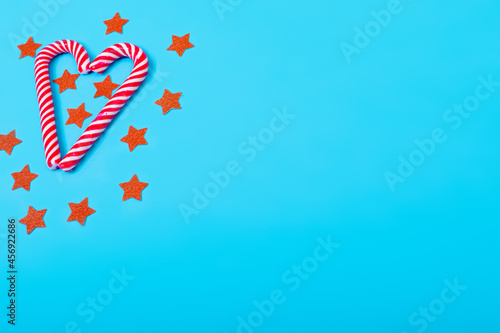 Composition of candy canes with stars and copy space on blue background