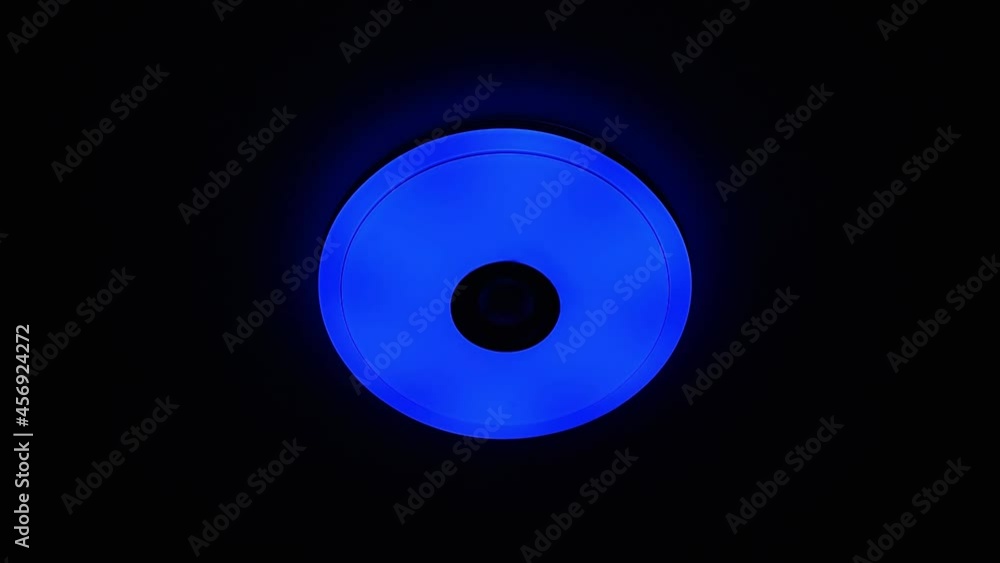 Red and blue light LED ceiling light with built-in wireless speaker over black background. Red and blue light LED ceiling light with built-in wireless speaker over black background.