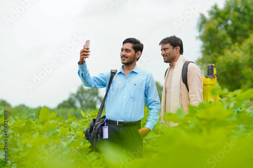 Photography Young indian agronomist or banker taking selfie with farmer at agriculture field