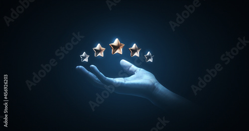 Hand holding review rating gold star sign or best excellent satisfaction five rate quality ranking success symbol on vote service rank background with like button and positive customer experience. photo