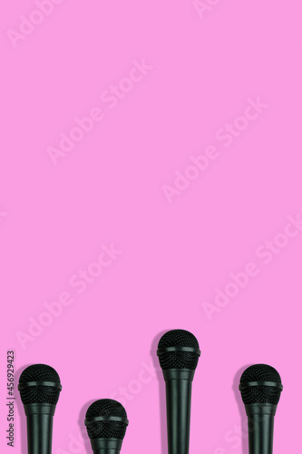black microphones pattern on pink background top view