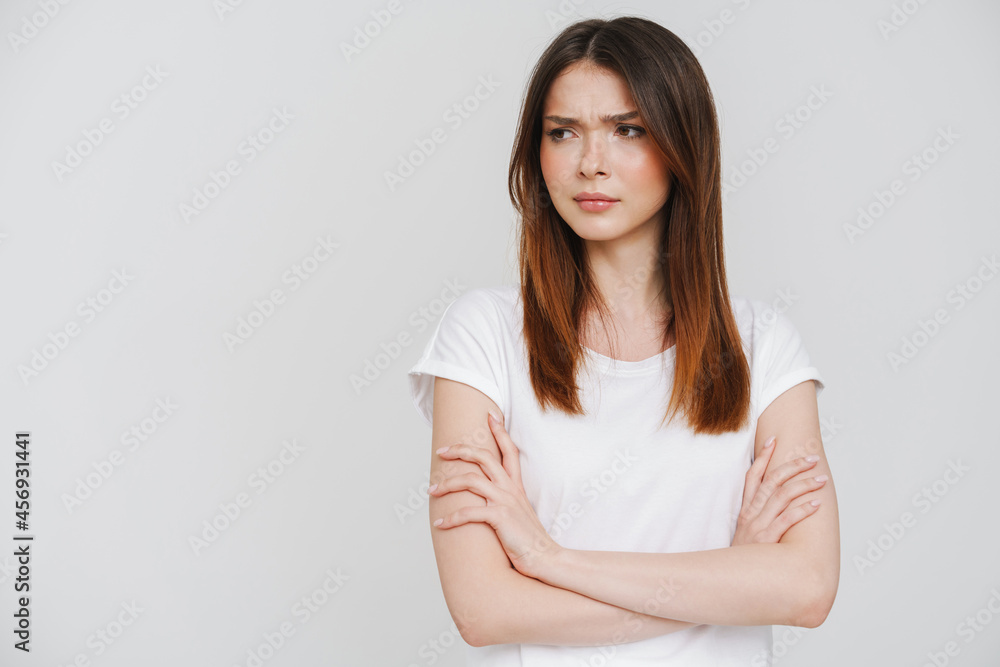 Young ginger woman in t-shirt frowning and looking aside Young ginger woman in t-shirt frowning and looking aside