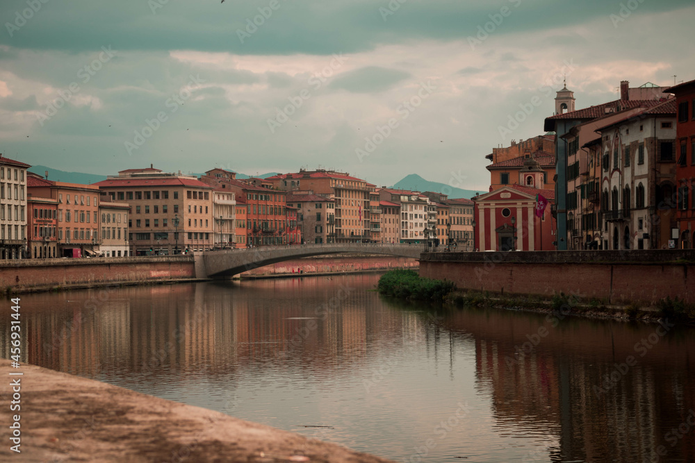 Pisa river, bridge and buildings on a cloudy day