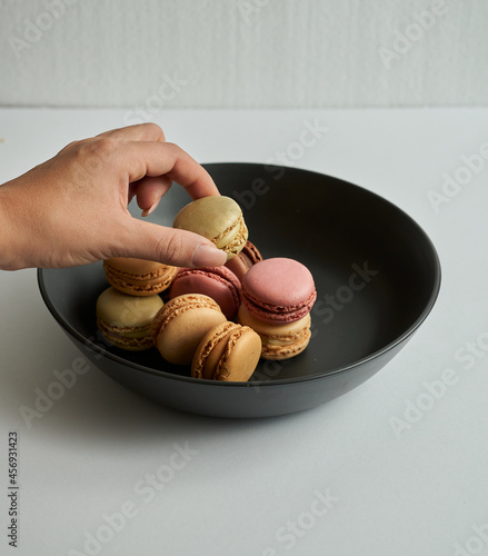 grabbing a macaron in a plate