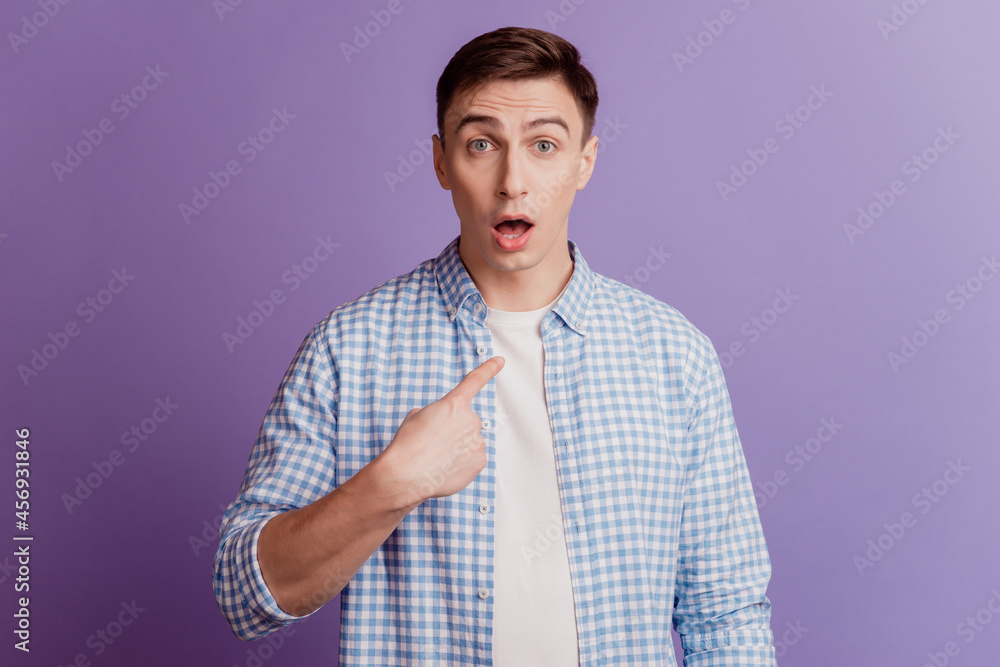 Portrait of shocked speechless guy direct finger himself omg reaction on purple background