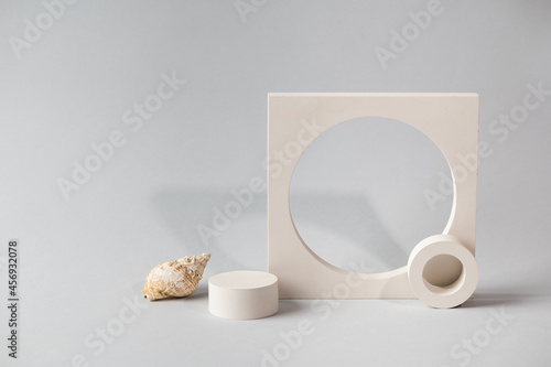 Product podium on grey background. Template  mock up for presentation products. Pastel colors styled composition with natural seashells and geometrical forms. Minimal concept. Cosmetic mockup