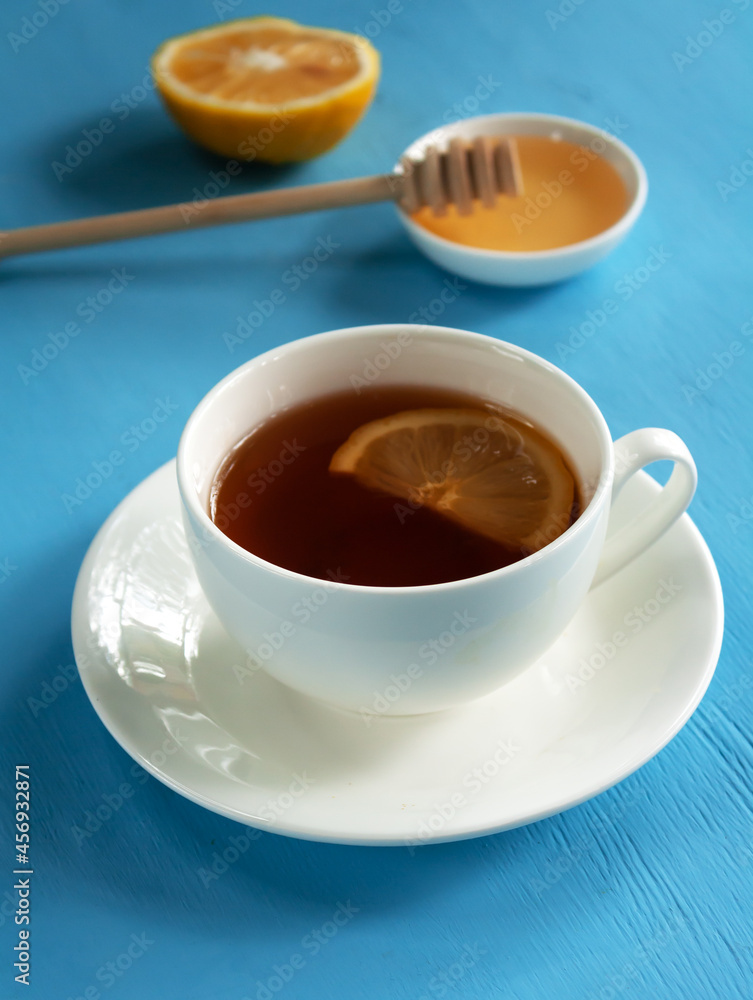 Antioxidant healthy black tea with lemon and honey on a blue background. Alternative medicine concept Antioxidant healthy black tea with lemon and honey on a blue background. Alternative medicine concept