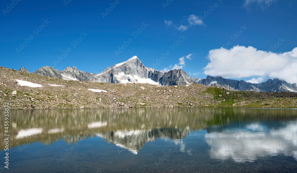 Rocky mountain reflecting in an mountain lake at a sunny day near Furka Pass. Uri Alps, Switzerland, Europe