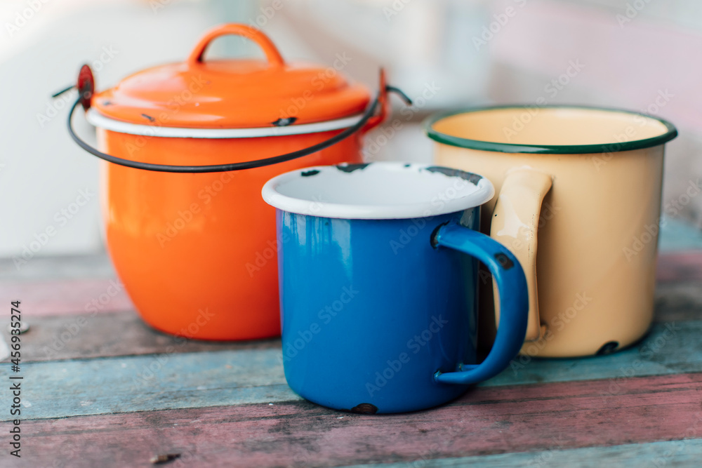 Colorful zinc glass bowls are gathered on a wooden table. Colorful zinc glass bowls are gathered on a wooden table.