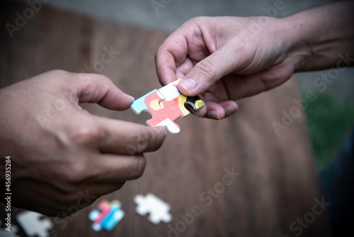 Stakeholders business team hands holding jigsaw puzzle as collaboration,connection and teamwork for business growth, business solution concept.selective focus.