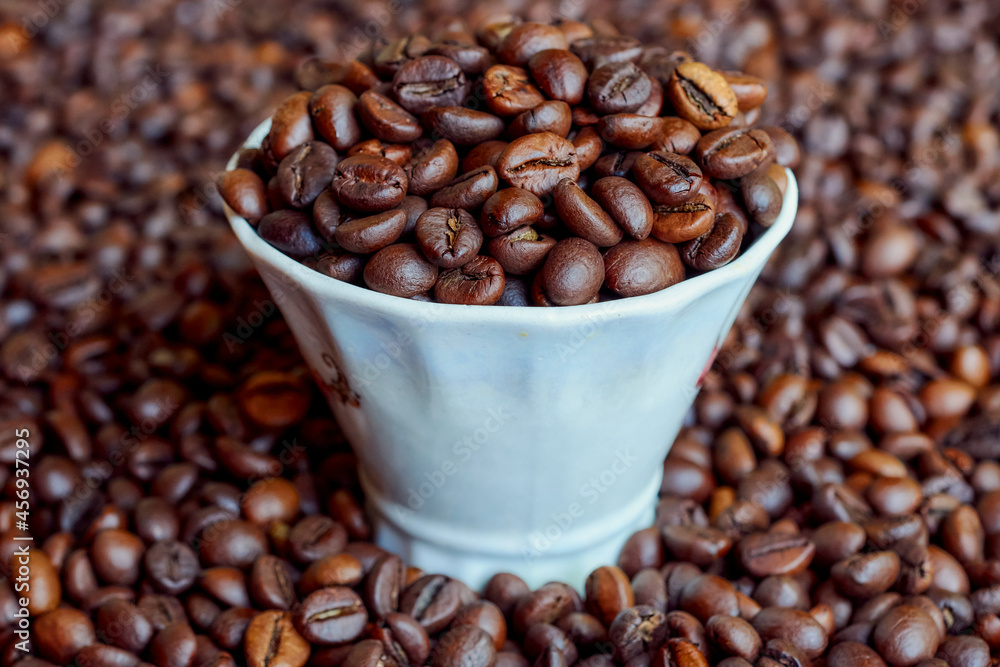 Fototapeta premium A cup full of freshly roasted coffee beans.