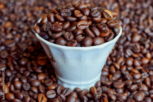 A cup full of freshly roasted coffee beans.