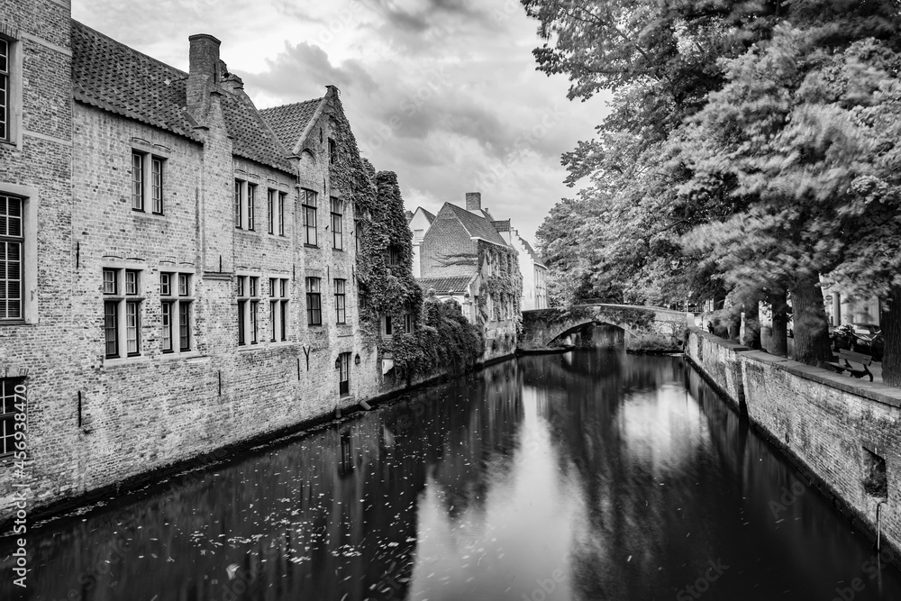 Long exposure black and white photograph of a water canal in the old center of Bruges, Belgium