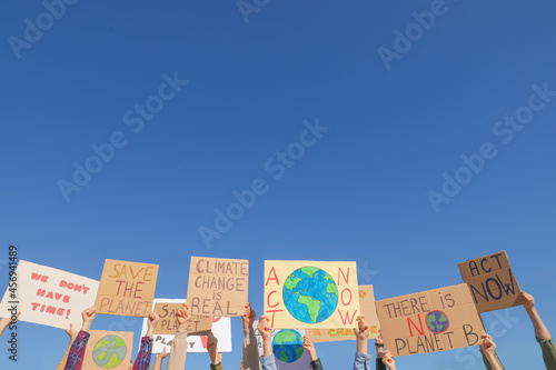 Group of people with posters protesting against climate change outdoors, closeup photo