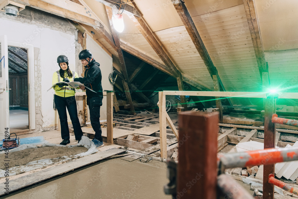 Male construction worker discussing with female engineer at site Male construction worker discussing with female engineer at site