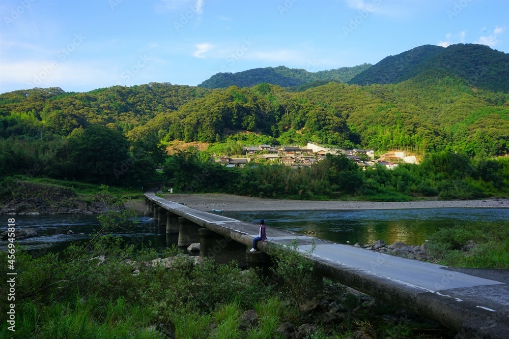 Woman sitting on Nagaoi Sinking bridge over Shimanto River Valley in Kochi, Shikoku, Japan - 日本 四国 高知 四万十川 長生沈下橋に座る女性