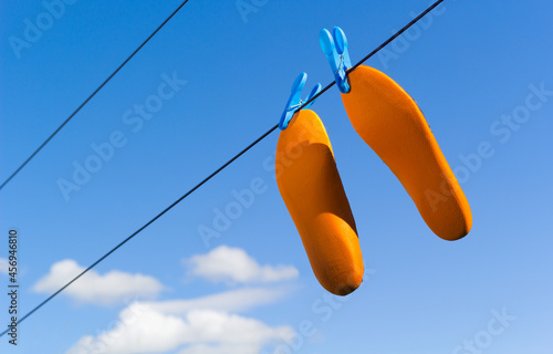 Orange footwear insoles drying on clothes or laundry line photo