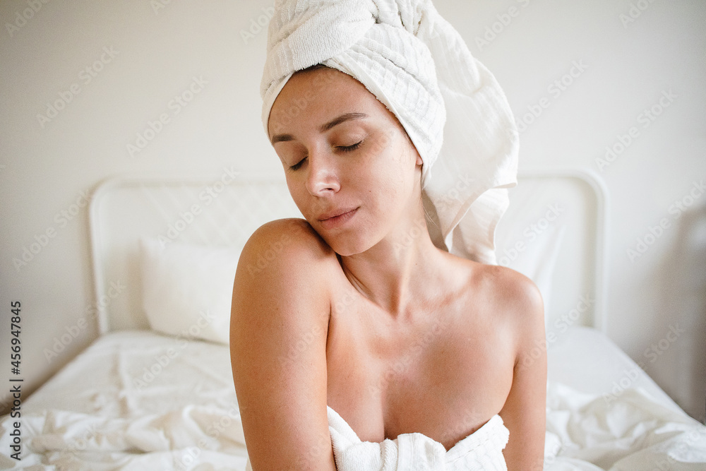 woman with natural soft skin at home doing self care routine with towel on her head in love with herself, feeling good and relaxing with eyes closed self love solitude comfortable natural light woman with natural soft skin at home doing self care routine with towel on her head in love with herself, feeling good and relaxing with eyes closed self love solitude comfortable natural light