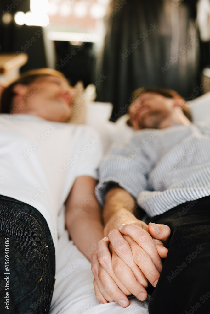 Gay couple holding hands while lying down in motor home during vacation Gay couple holding hands while lying down in motor home during vacation