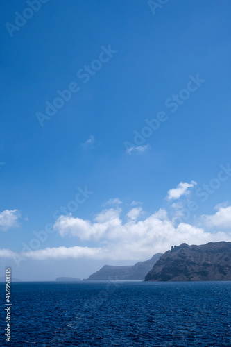 Scenic landscape of Aegean sea at sunny summer day. Santorini island. Silhouettes of islands in mist. © Anastasia