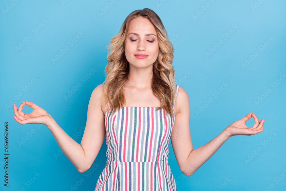 Photo of young woman happy positive smile yoga meditate asana calm isolated over blue color background Photo of young woman happy positive smile yoga meditate asana calm isolated over blue color background