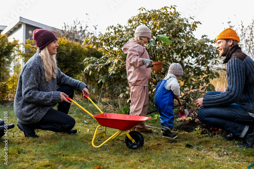 Happy family doing gardening together at back yard photo