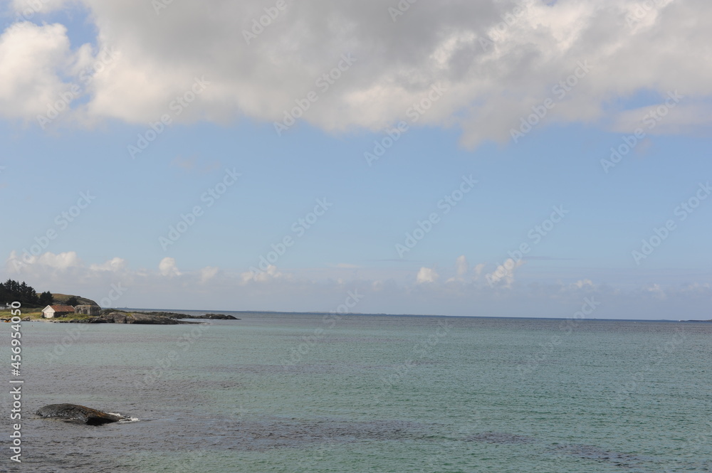 Sola sand beach at the North Sea coast in Stavanger, Norway with a blue sky and white clouds and waves in summer