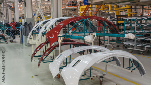 Auto bumpers parts are installed on the racks after painting in the car factory. Industry concept. © kalyanby