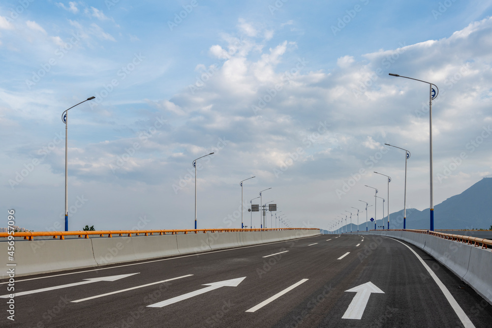 Fototapeta premium Empty asphalt highway road with city skyline.
