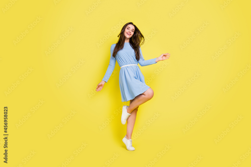 Photo of sweet charming young lady wear dotted outfit smiling dancing isolated yellow color background Photo of sweet charming young lady wear dotted outfit smiling dancing isolated yellow color background