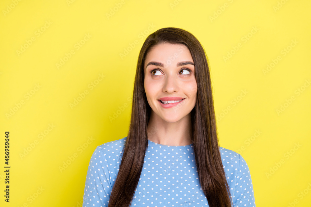 Fototapeta premium Photo of curious tempting girl bite lip look empty space wear dotted blue dress isolated yellow color background