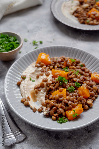 Vegan healthy food. Lentils and butternut squash with houmus and green herbs, clean eating concept