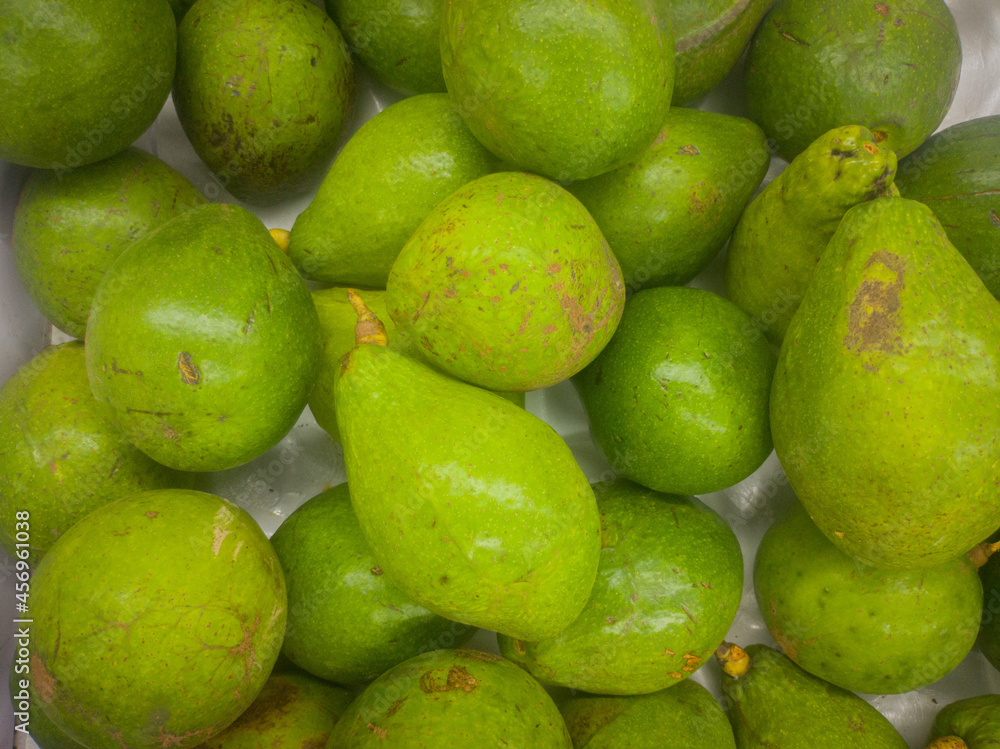 background texture of a pile of avocados for sale in the market