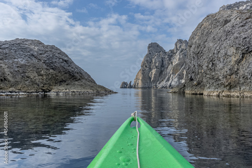 View from the nose of a green sea kayak that floats between the stones and mount Karaul-Oba on the sea. Crimea. Novy Svet