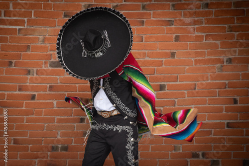 Mexican charro dancer with sombrero and multicolored serape from jalisco mexico with mariachi music photo