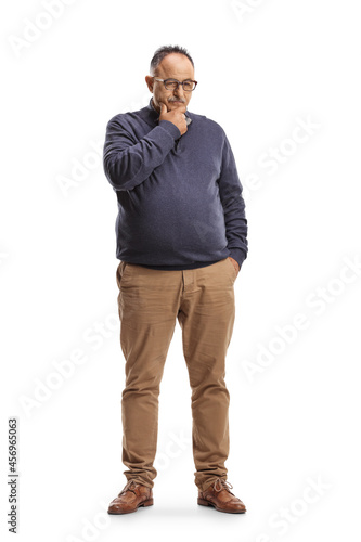 Full length portrait of a pensive mature man standing and thinking