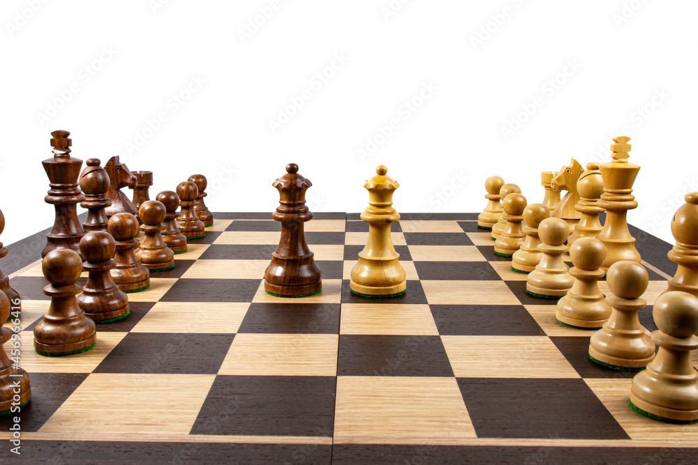 Large chessboard with pieces, white backdrop, the concept of a fair fight or opposition of different forces,  copy space.