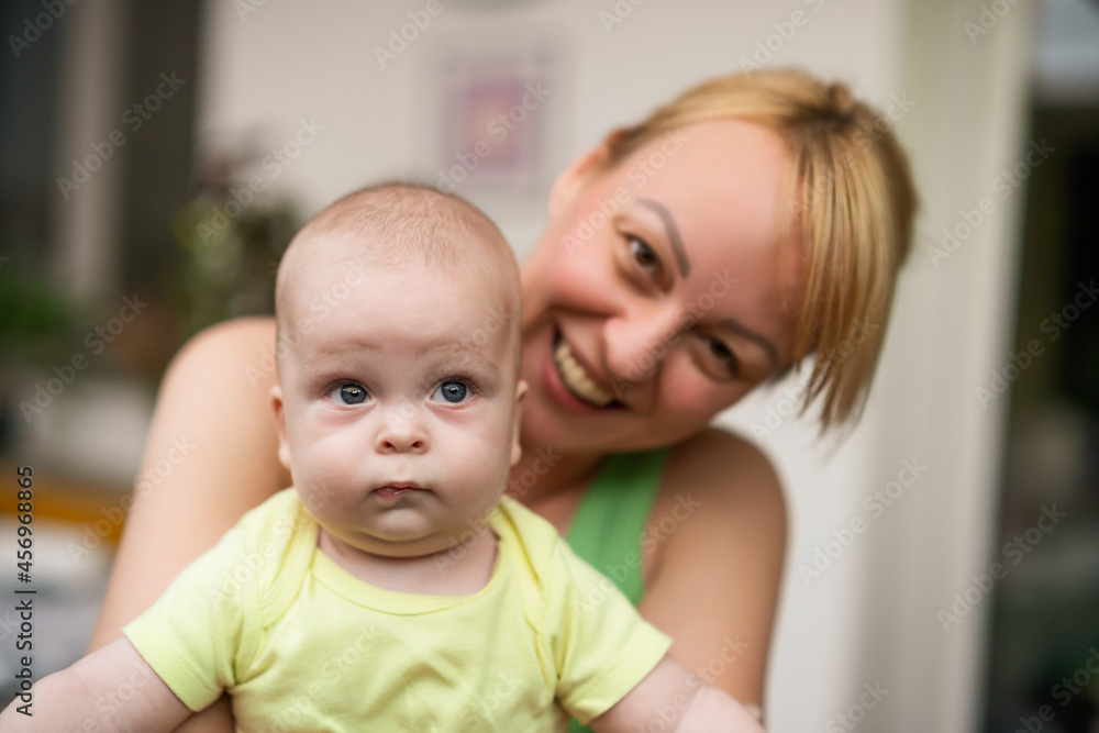 Mother enjoys holding her little cheerful baby boy. Mother enjoys holding her little cheerful baby boy.