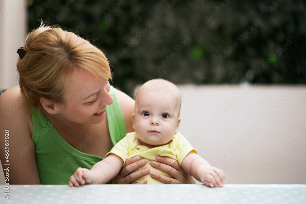 Mother enjoys spending time with her little cheerful baby boy. Mother enjoys spending time with her little cheerful baby boy.