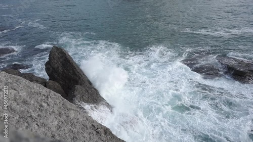 Water splashing. Sea water beats against rocks. Sea waves of blue-gray water beat against the coastal rocks. An infinite number of splashes, drops of water and white foam are scattered. Novy Svet